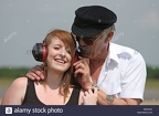 a-teenage-girl-wearing-ear-defenders-at-an-air-show-with-her-grandfather-BDCNJD