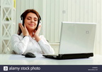 young-beautiful-businesswoman-listening-music-in-headphones-at-office-DK6M5C