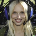 A high resolution photo of a cute, smiling young blonde woman wearing a large helicopter headset, detailed, realistic (4)