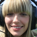 A high resolution photo of an attractive smiling young blonde woman with bangs wearing a large helicopter headset, detailed, realistic (5)