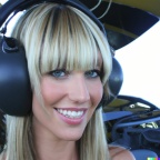 A high resolution photo of an attractive smiling young blonde woman with bangs wearing a large helicopter headset, detailed, realistic (6)