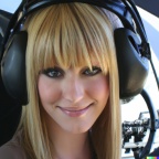 A high resolution photo of an attractive smiling young blonde woman with bangs wearing a large helicopter headset, detailed, realistic (7)