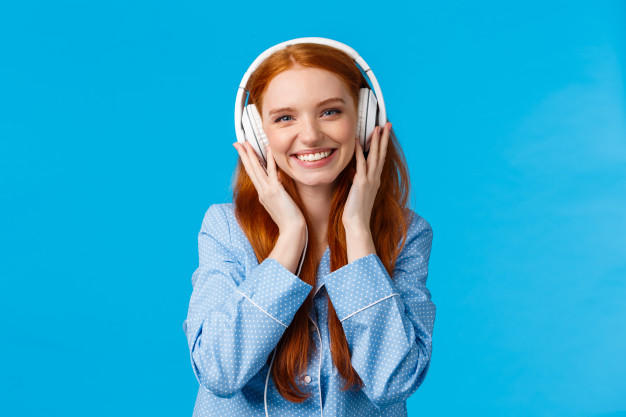 waist-up-shot-cheerful-pretty-foxy-caucasian-girl-listening-music-large-headphones-smiling-pleased-checking-out-friends-single-wearing-nightwear-standing-blue-wall-delighted_1258-9746.jpg