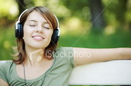 istockphoto 4008830-relaxed-young-woman-listening-music-in-park