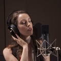 Brunette with eyes closed wears AKG K240 headphones in studio