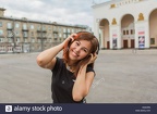 beautiful-asian-girl-listening-to-music-with-headphones-on-the-street-H2AHRN