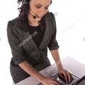 stock-photo-a-business-woman-working-on-her-computer-with-her-headset-on-44382877