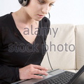 a-young-woman-working-with-headset-and-laptop-at-home-cwfnwn