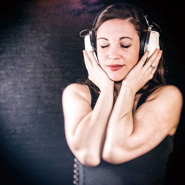 Brunette closes her eyes and clasps vintage headphones tightly.jpg
