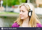 woman-with-headphones-by-canal-E5WP30