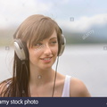 young-woman-wearing-headphones-at-lakeside-under-bright-sunlight-EA05F7.jpg