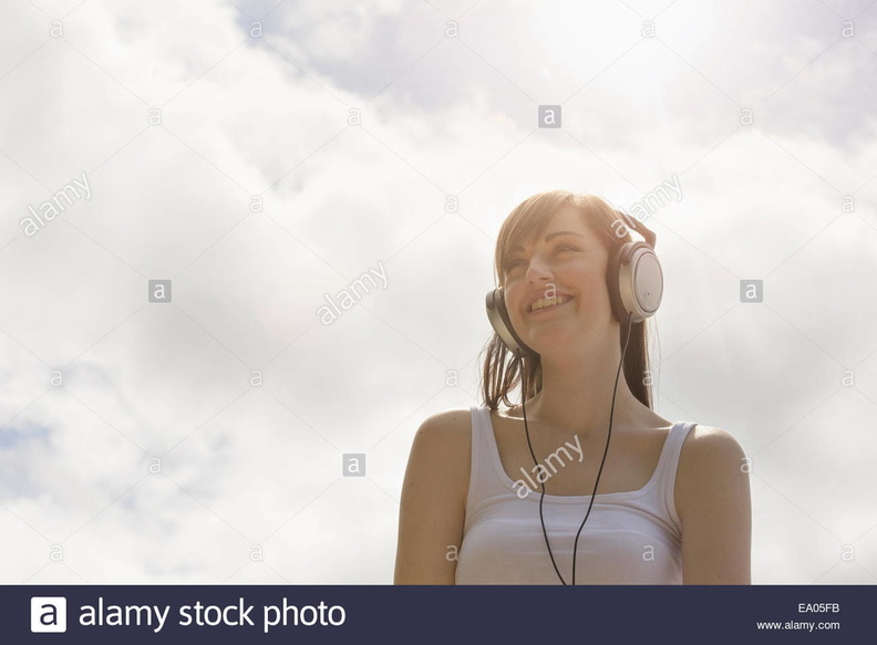 young-woman-wearing-headphones-under-bright-sunny-sky-EA05FB