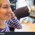 stock-photo-close-up-of-happy-young-female-radio-host-broadcasting-in-studio-329428637