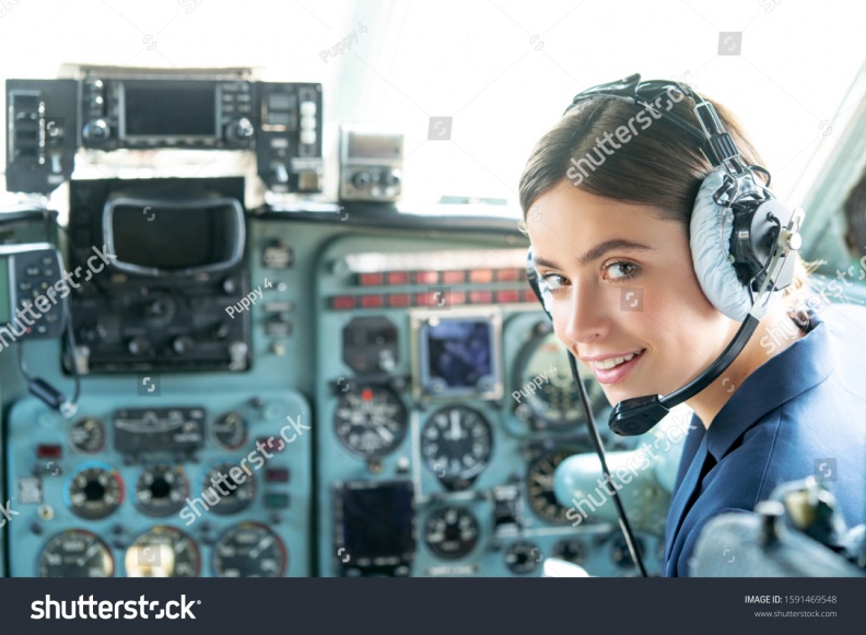 stock-photo-happy-and-successful-flight-smiling-female-pilot-in-the-aircraft-she-is-holding-aviator-headset-1591469548.jpg