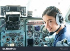 stock-photo-happy-and-successful-flight-smiling-female-pilot-in-the-aircraft-she-is-holding-aviator-headset-1591469548