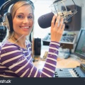 stock-photo-portrait-of-happy-young-female-radio-host-broadcasting-in-studio-324754328