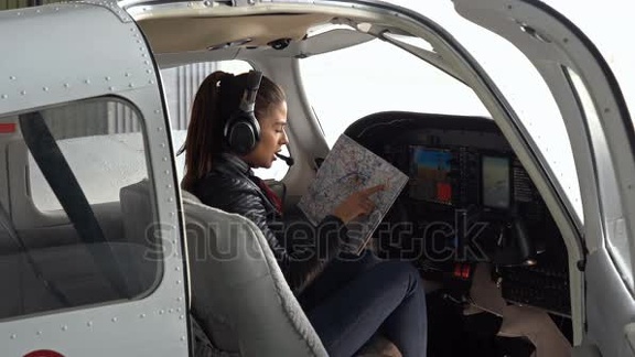 stock-footage-young-woman-pilot-talking-over-communication-device-attractive-woman-pilot-with-headset-sitting-in