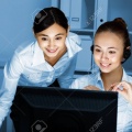 13383002-young-woman-in-business-wear-in-headset-working-with-computer