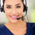 18983644-closeup-portrait-of-a-happy-young-call-centre-employee-smiling-with-a-headset