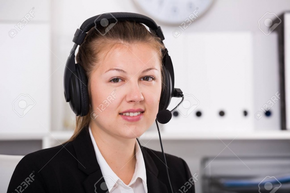 82228166-portrait-of-dispatcher-female-in-black-suit-which-is-talking-by-headset-with-client-in-the-office-