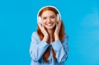waist-up-shot-cheerful-pretty-foxy-caucasian-girl-listening-music-large-headphones-smiling-pleased-checking-out-friends-single-wearing-nightwear-standing-blue-wall-delighted 1258-9746
