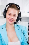 89695007-office-worker-woman-is-working-at-a-computer-and-talking-by-headset-with-client-in-the-office-