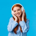 technology-lifestyle-people-concept-cute-redhead-woman-pyjama-listen-music-headphones-enjoy-nice-beats-earphones-good-quality-new-songs-standing-blue-wall 1258-6588