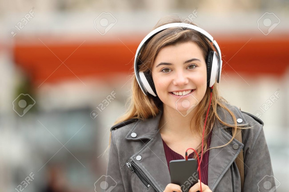 71234198-front-view-of-a-happy-young-adult-girl-listening-music-on-line-with-headphones-and-looking-at-you-in
