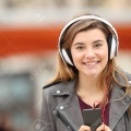 71234198-front-view-of-a-happy-young-adult-girl-listening-music-on-line-with-headphones-and-looking-at-you-in