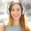 115350246-front-view-portrait-of-a-teenage-girl-wearing-headphones-listening-to-music-looking-at-camera-in-the.jpg