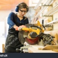 stock-photo-attractive-female-carpenter-using-some-power-tools-for-her-work-in-a-woodshop-586570931