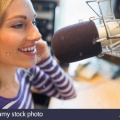 happy-young-female-radio-host-broadcasting-in-studio-FH0TRY