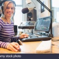 portrait-of-female-radio-host-using-computer-in-studio-F35F80