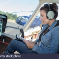 female-helicopter-pilot-reading-a-manual-while-sitting-in-cockpit-PATM86