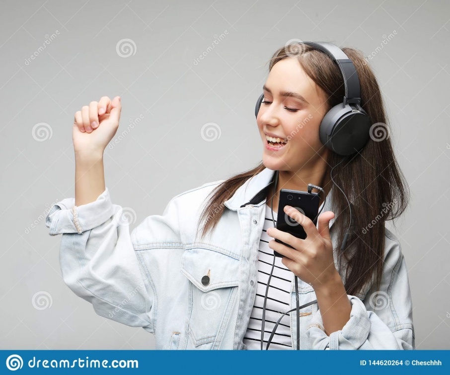 beautiful-young-woman-listening-to-music-headphones-smartphone-lifestyle-people-concept-grey-background-144620264