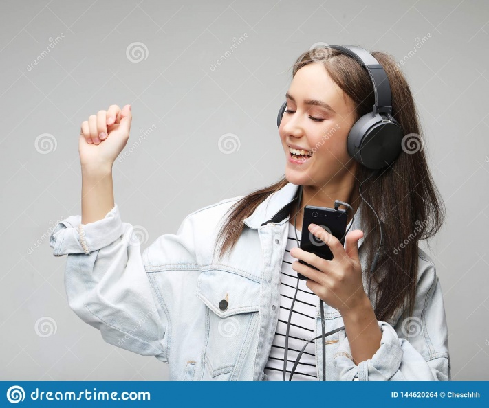 beautiful-young-woman-listening-to-music-headphones-smartphone-lifestyle-people-concept-grey-background-144620264.jpg