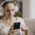 girl-connecting-her-phone-listening-to-music-happy-young-woman-home-smartphone-wearing-headphones-149779639