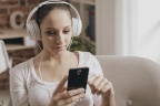 girl-connecting-her-phone-listening-to-music-happy-young-woman-home-smartphone-wearing-headphones-149779639