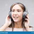 young-woman-headphones-listening-to-music-beautiful-standing-grey-background-pink-t-shirt-145026317