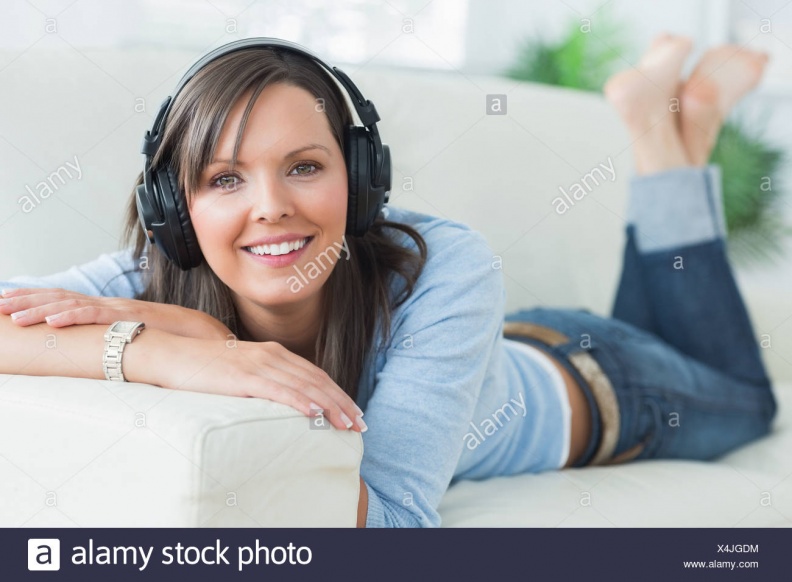 woman-listening-music-looking-happy-on-sofa-X4JGDM.jpg