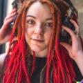 A young adult caucasian woman with red dreadlocks and green eyes wearing large black vintage headphones (2)
