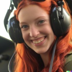 A high resolution photo of a cute, smiling young redheaded Caucasian woman wearing a large helicopter headset, detailed, realistic (7)