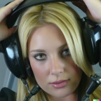 A high resolution photo of an attractive shy young blonde woman wearing a helicopter headset, detailed, realistic (2)