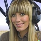 A high resolution photo of an attractive smiling young blonde woman with bangs wearing a large helicopter headset, detailed, realistic (4)