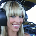 A high resolution photo of an attractive smiling young blonde woman with bangs wearing a large helicopter headset, detailed, realistic (6).jpg