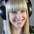 A high resolution photo of an attractive smiling young blonde woman with bangs wearing large black vintage headphones, detailed, realistic (2).jpg