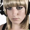 A high resolution photo of an attractive young blonde woman with bangs wearing large black vintage headphones, detailed, realistic.jpg