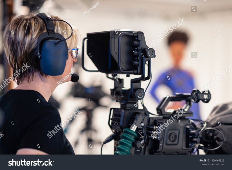 stock-photo-a-close-up-of-a-camerawoman-wearing-a-headset-looking-through-the-film-camera-viewfinder-while-1829464322.jpg
