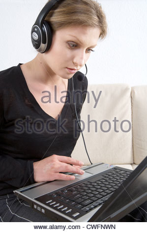 a-young-woman-working-with-headset-and-laptop-at-home-cwfnwn.jpg